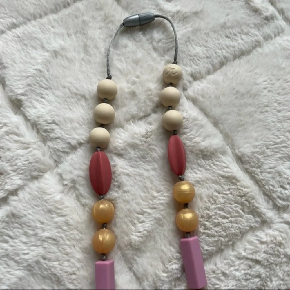 Itzy Ritzy | Teething Happens Chewable Mom Necklace | Pink & Gold